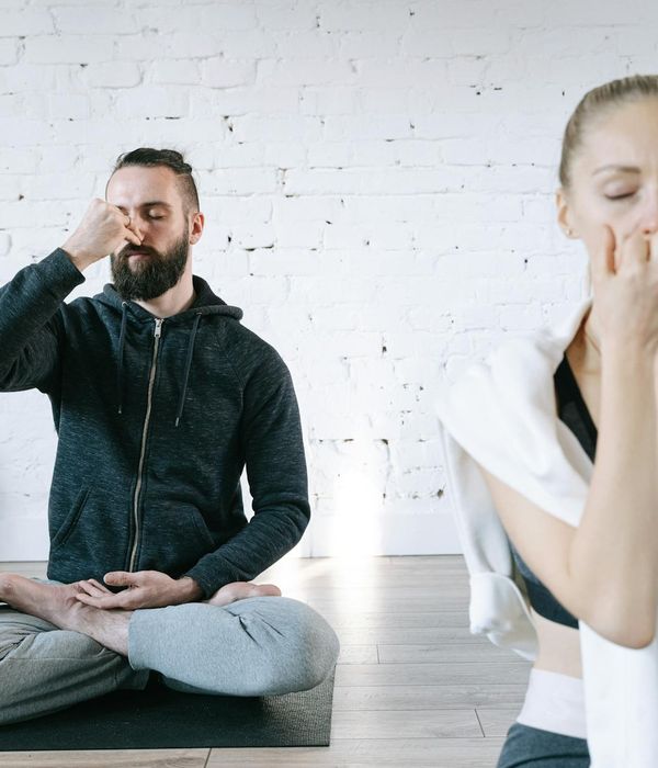 Woman in a peaceful yoga pose in a bright, serene room.